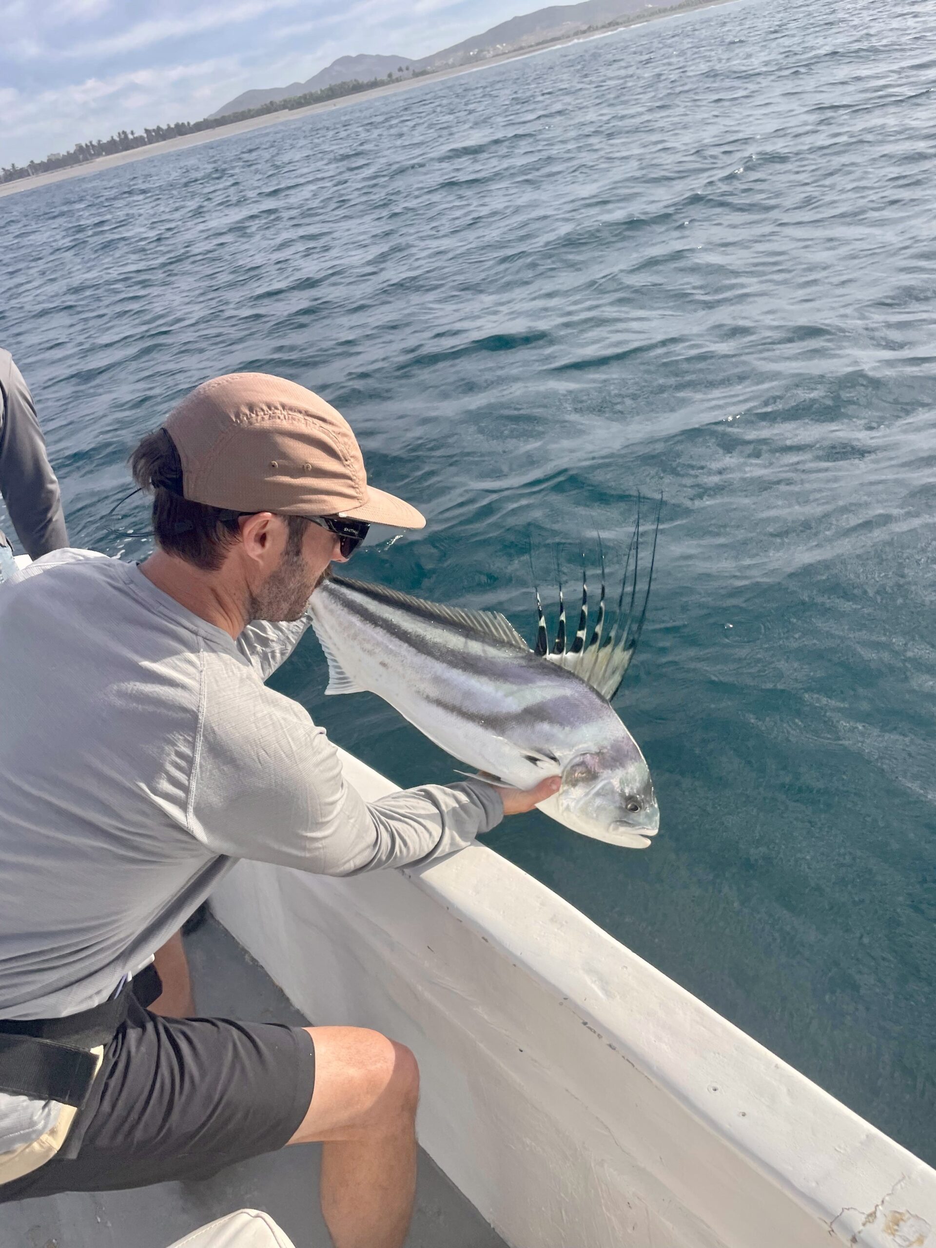 Captain assisting with roosterfish catch near Punta Gorda Cabo
