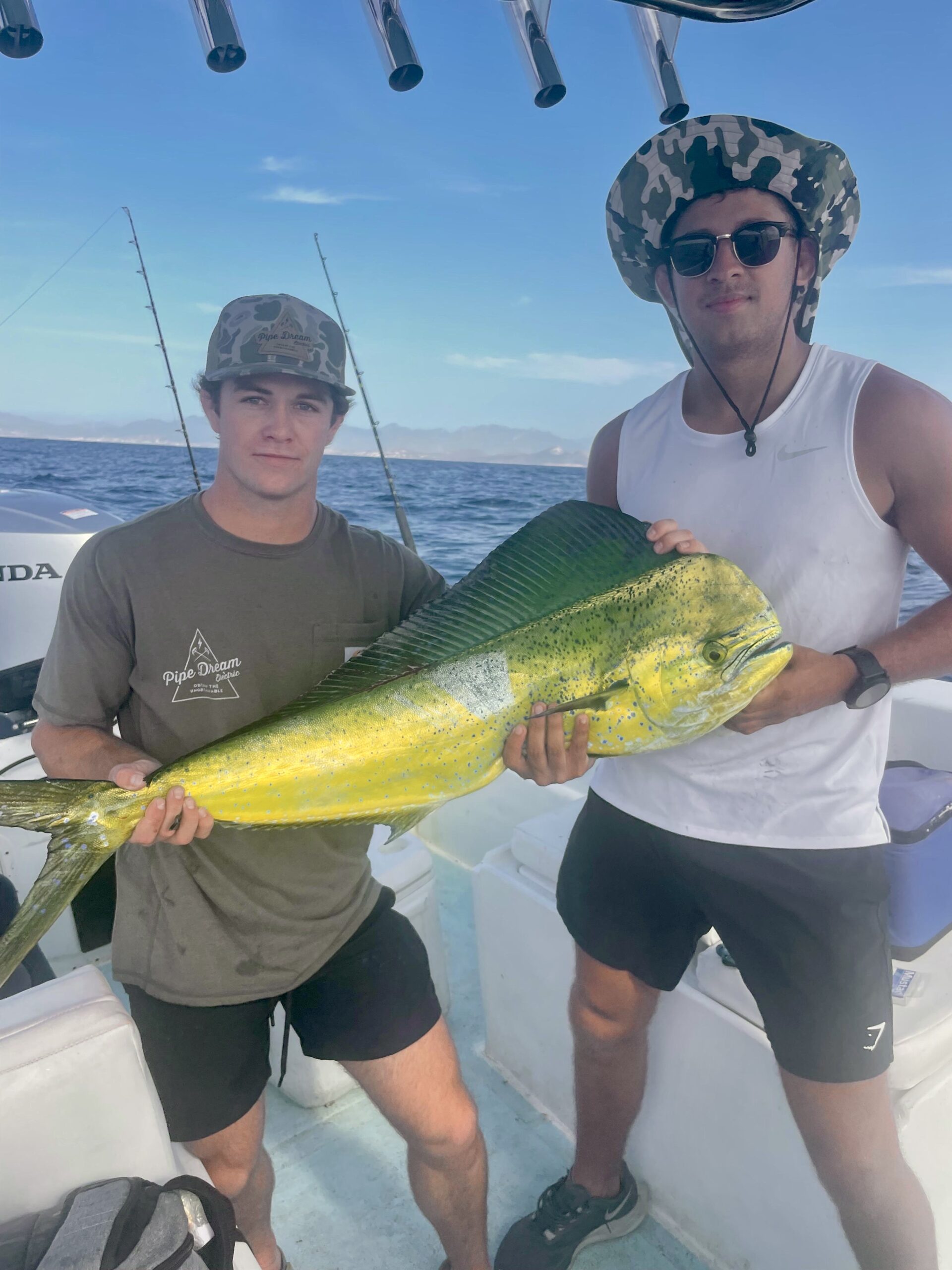 Tourists holding mahi mahi before snorkeling stop in Los Cabos