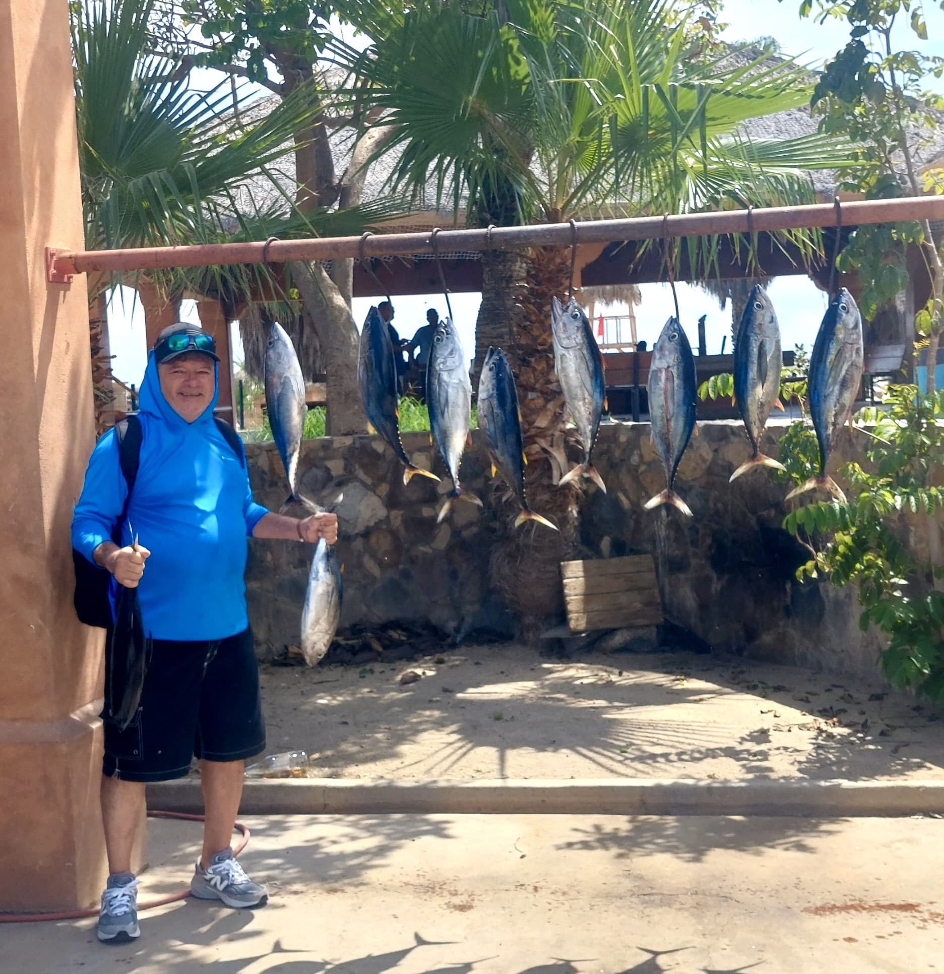 Angler with a stack of 10 school tuna 10–15 lb