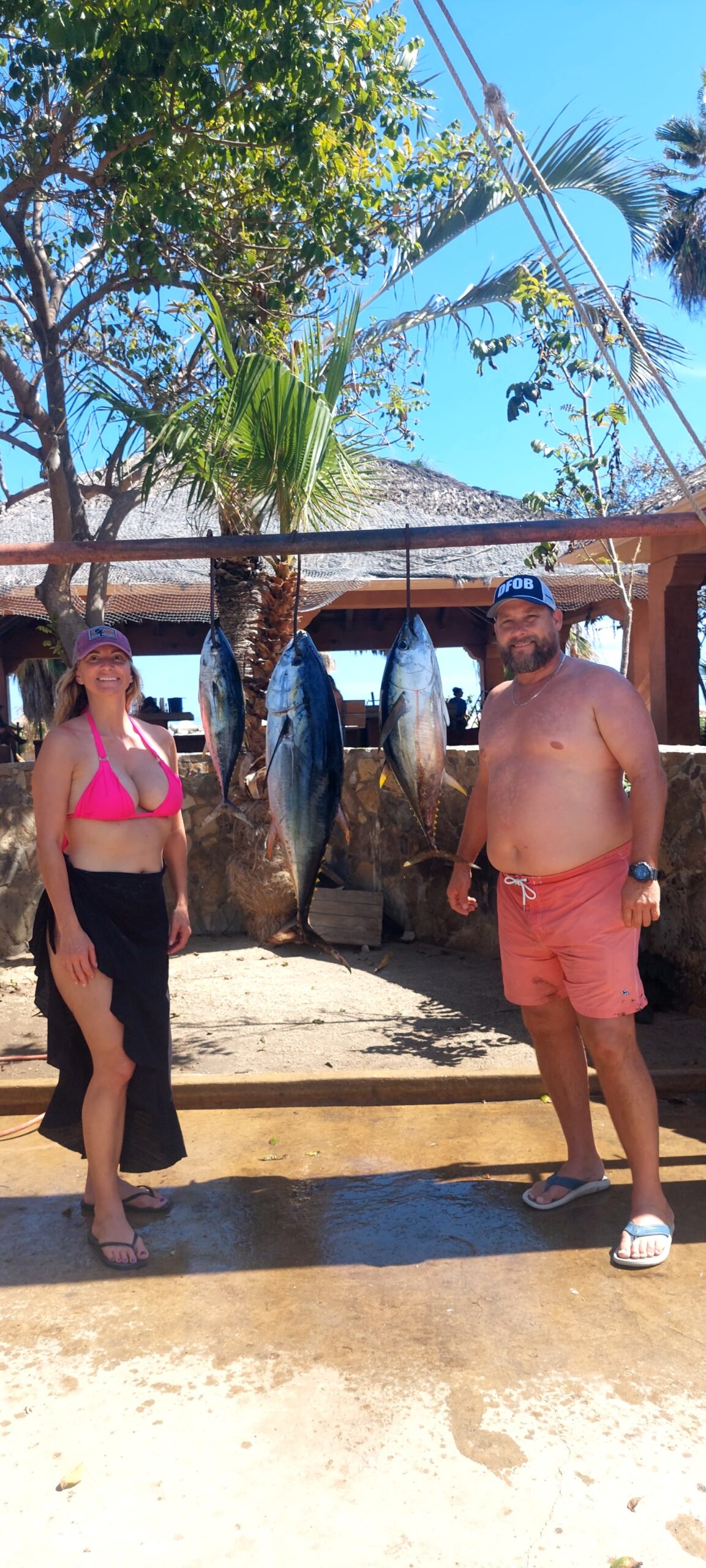 Clients with hanging tunas at the dock after a successful charter