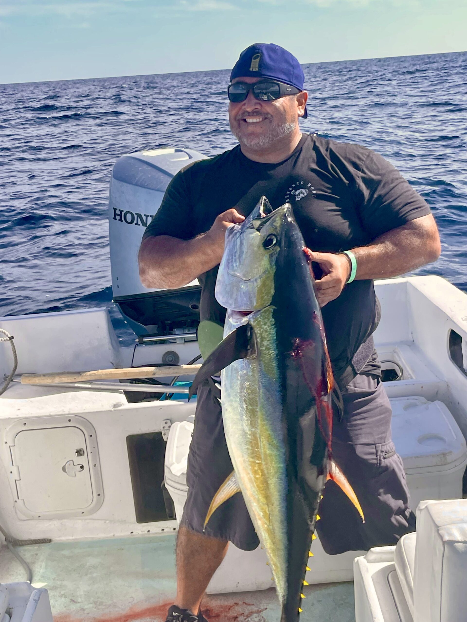 Two anglers showing off a freshly caught tuna aboard a Daliken Sportfishing boat