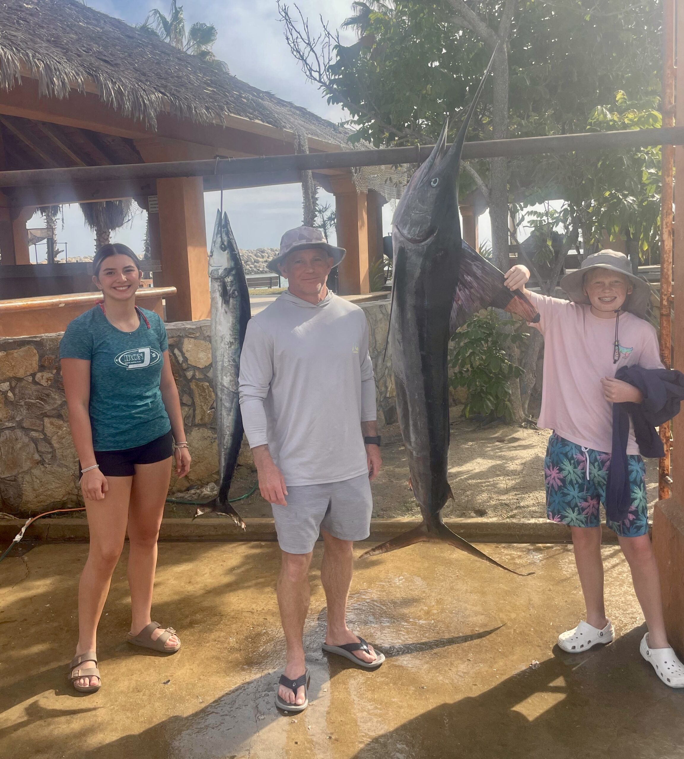 Happy guests on a Daliken Sportfishing charter holding a striped marlin in San José del Cabo