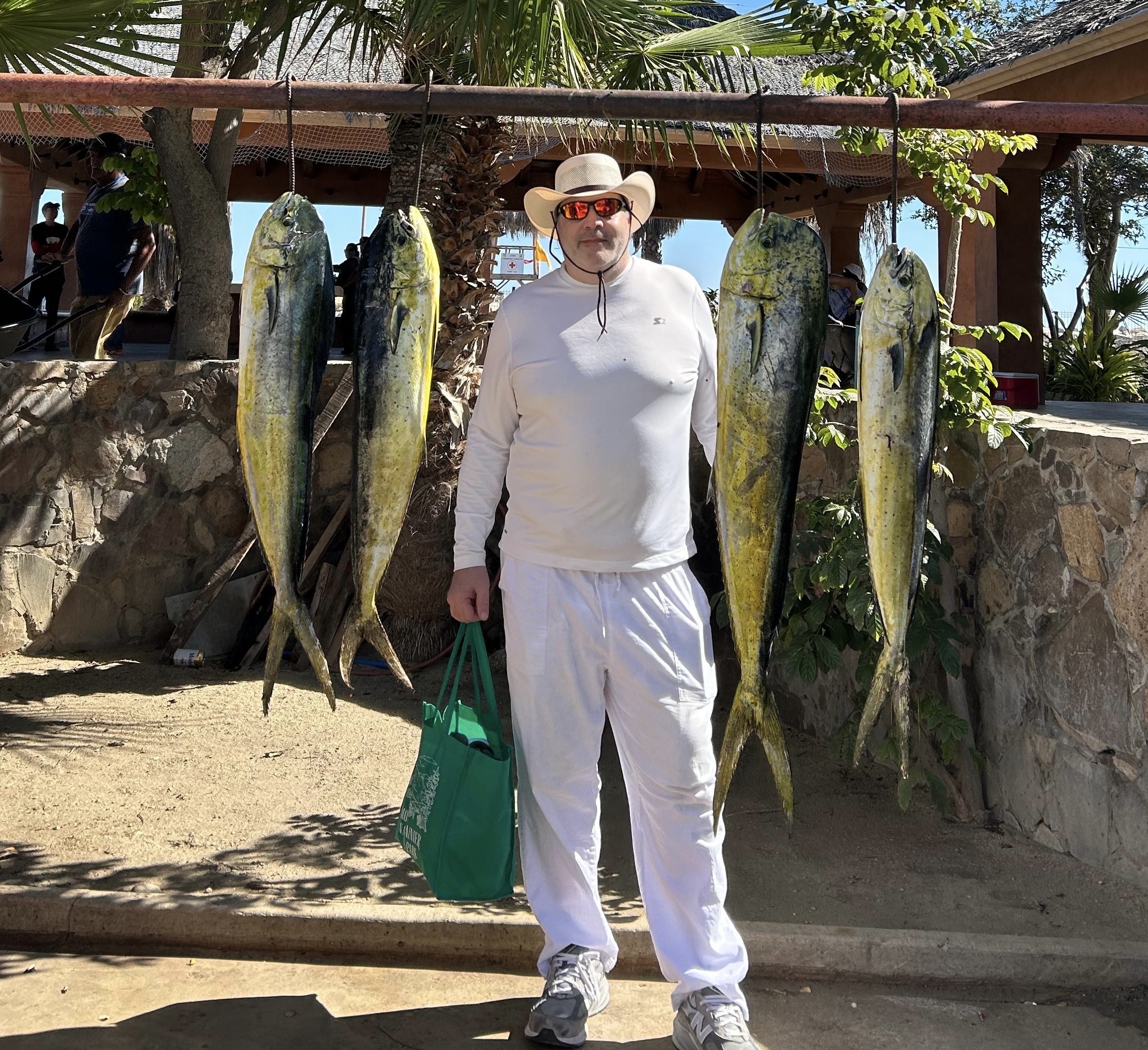 Daliken Sportfishing clients holding a fresh-caught mahi mahi (dorado) in San José del Cabo near La Fortuna
