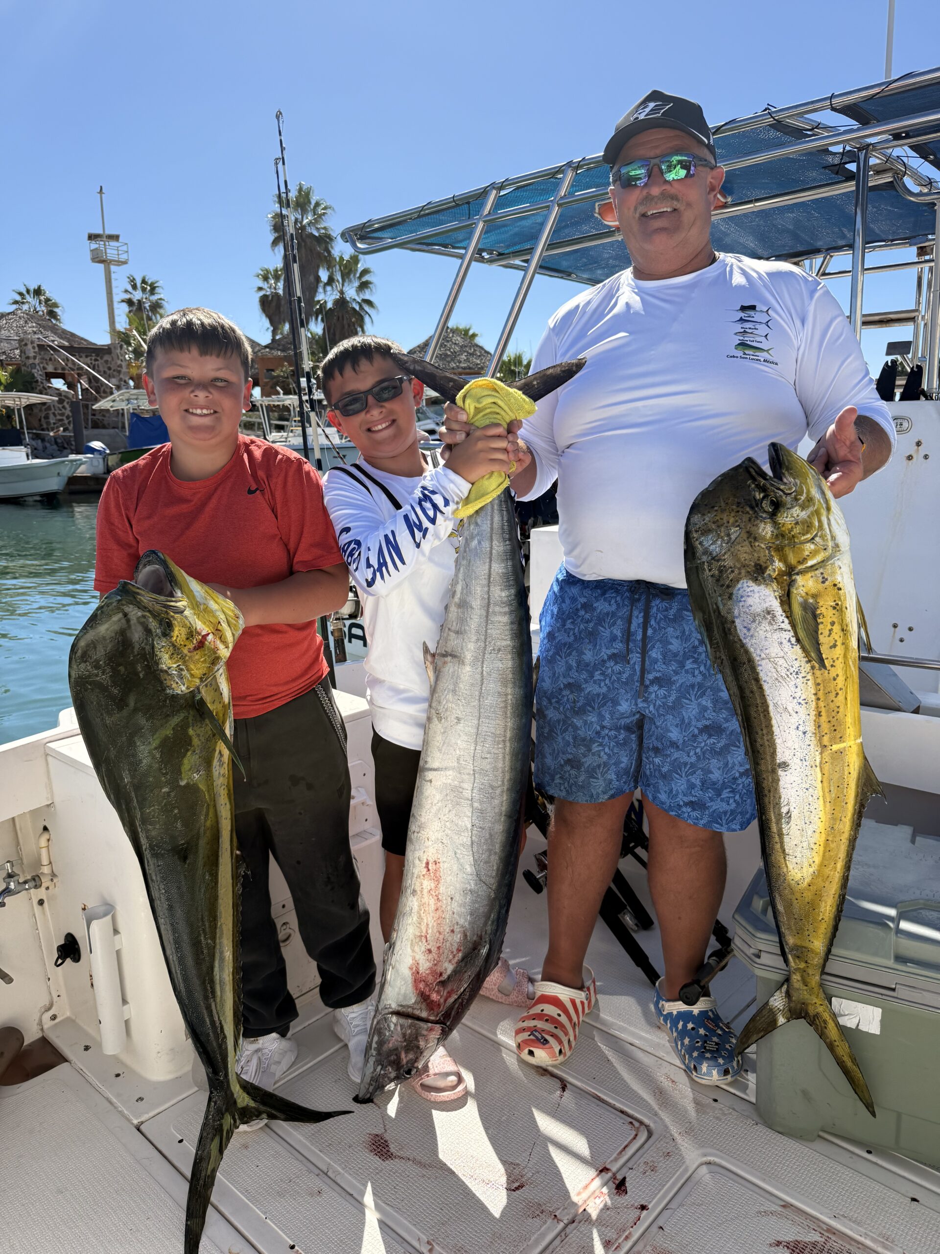 Daliken Sportfishing clients holding fresh mahi mahi catch in San José del Cabo after a successful offshore trip