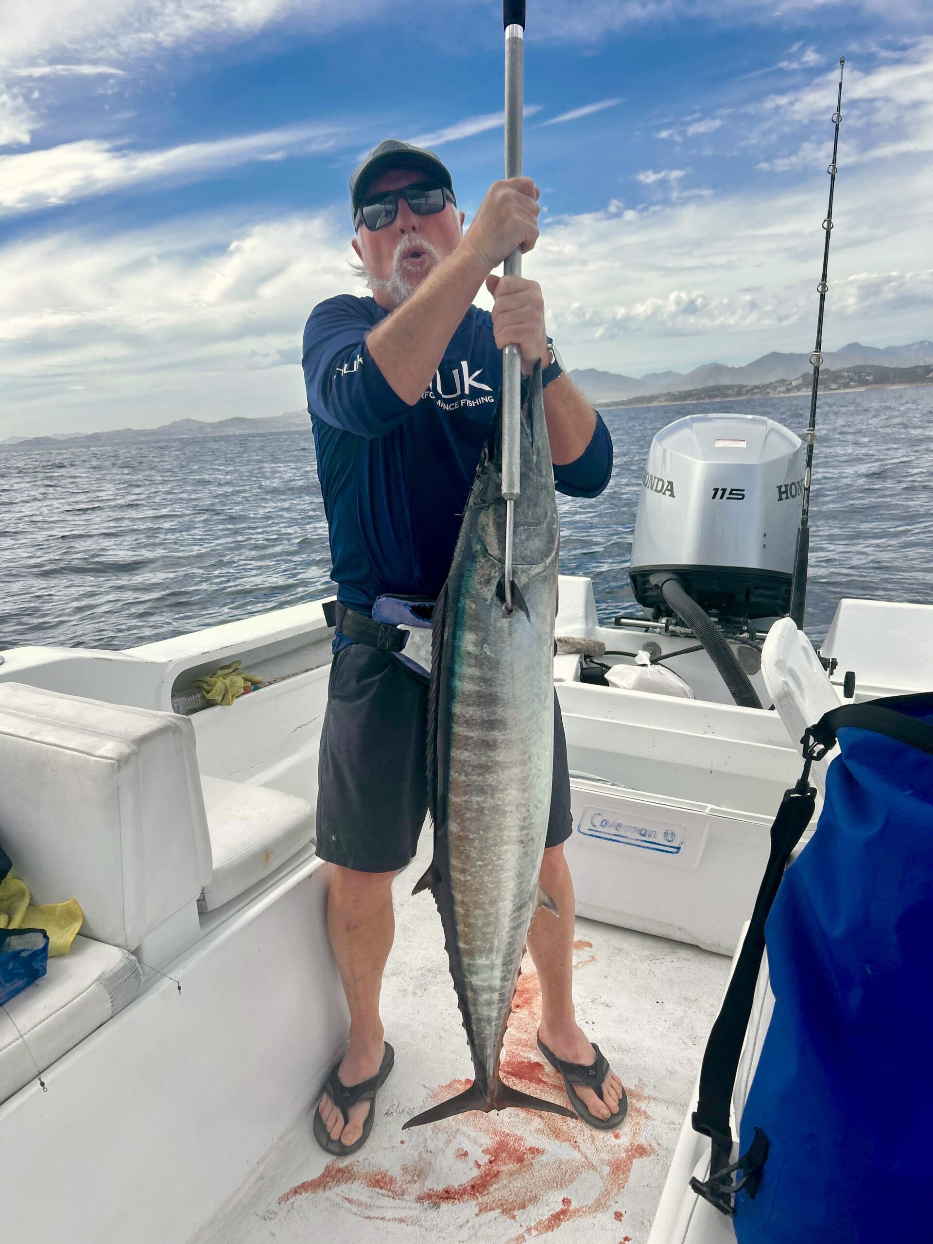 Client holding a wahoo caught offshore near San José del Cabo on a private fishing charter